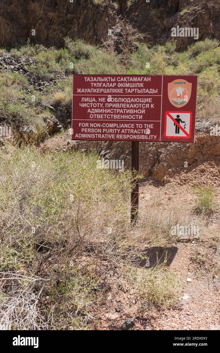 Kasachstan, Charyn (Sharyn) Canyon. Dreisprachiges Schild Warnung, dass das Verwerfen von Abfall mit verwaltungsrechtlicher Strafe geahndet wird. Stockfoto