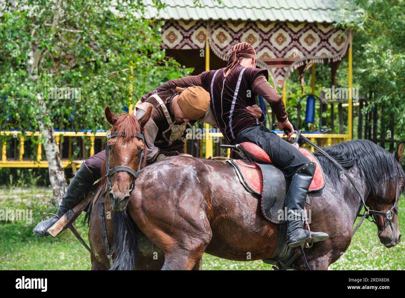 Kasachstan, Hunnen-Ethno-Dorf. Demonstration der traditionellen kasachischen Nomadischen Kampfkunst auf dem Pferderücken. Stockfoto