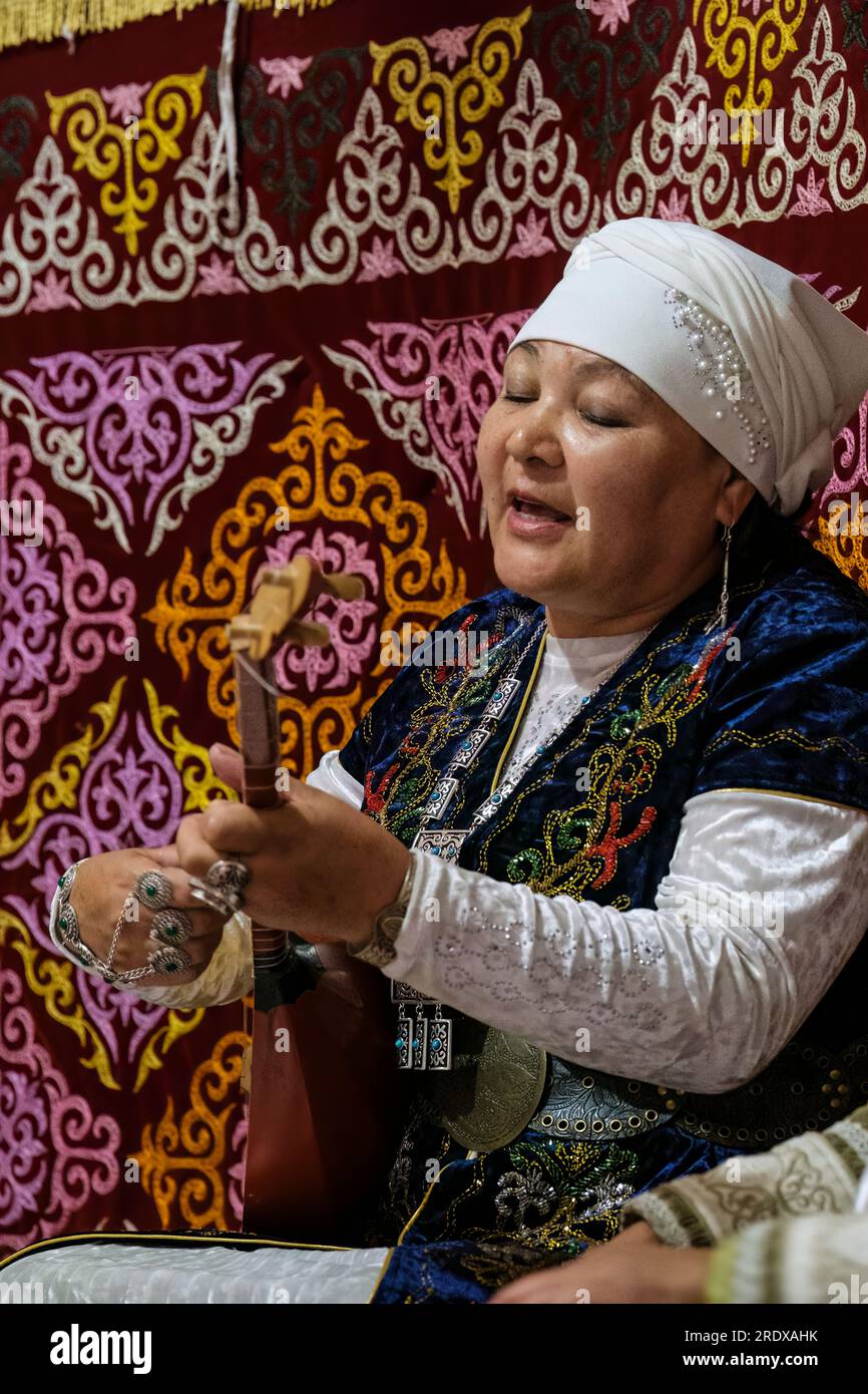 Kasachstan, Hunnen-Ethno-Dorf. Eine Kasacherin, die in einem Jurten die Dombra spielt. Stockfoto