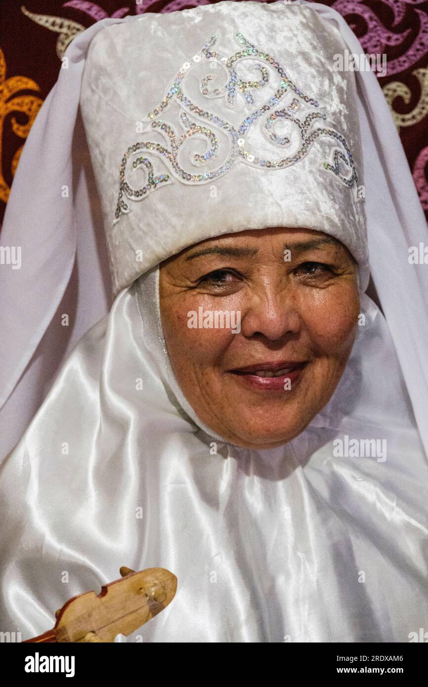 Kasachstan, Hunnen-Ethno-Dorf. Kasachische Frau mittleren Alters in traditionellem Kopfschmuck. Stockfoto