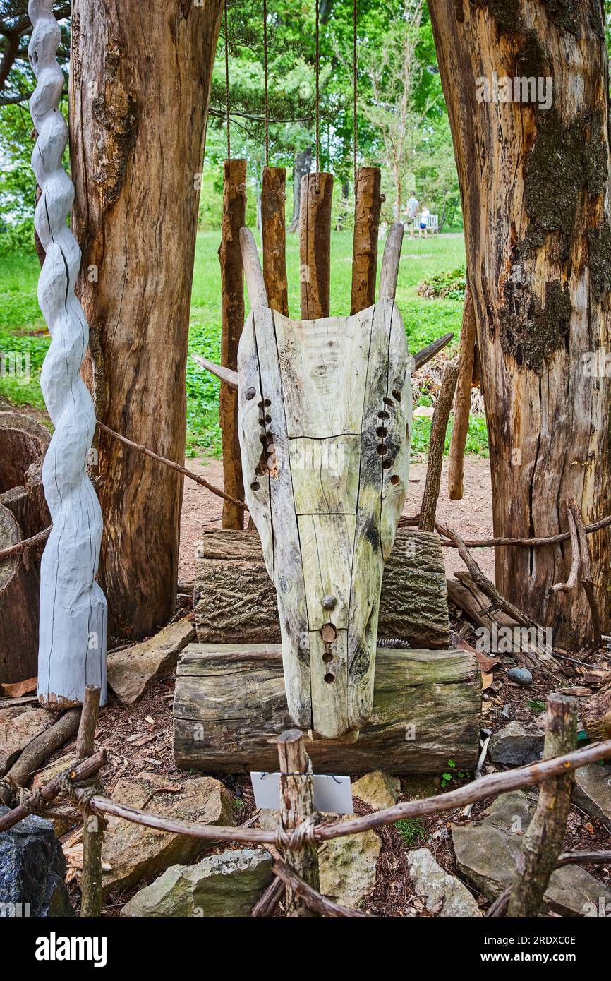 Vorderansicht des hölzernen Drachenköpfels auf Holzstämmen neben dem hohen weißen Einhorn Stockfoto