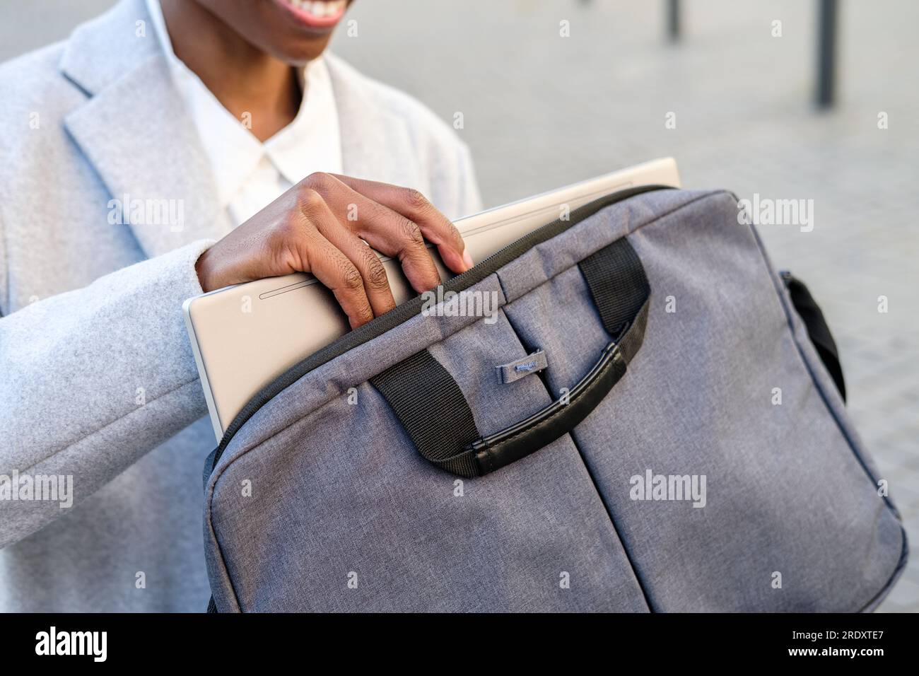 Nicht wiedererkennbare afrikanerin, die den Laptop aus der Tasche nimmt. Selektive Fokussierung auf die Hände Stockfoto