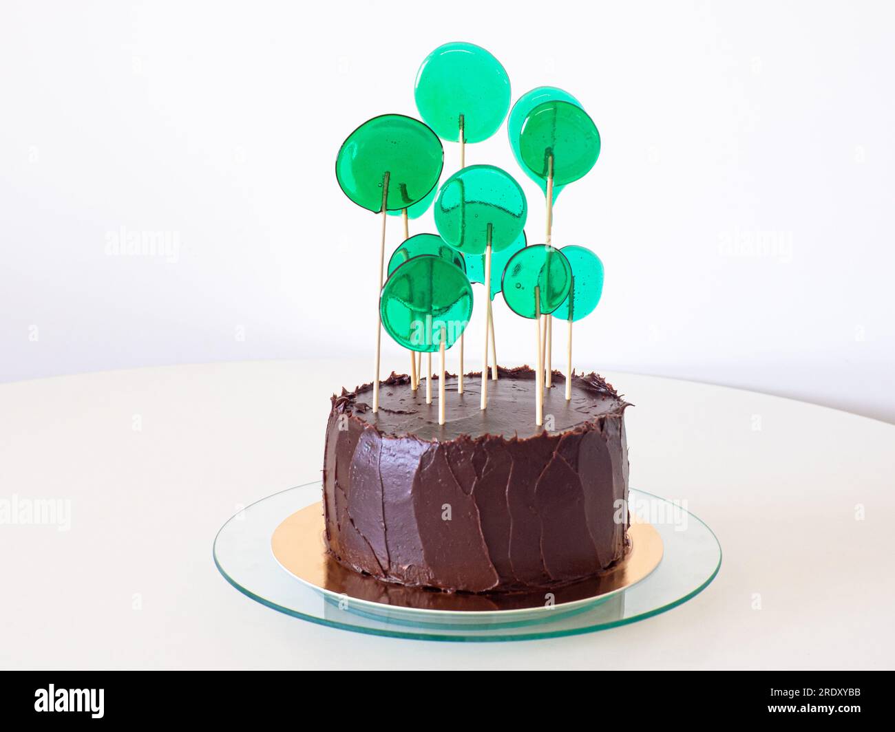 Schokoladenkuchen mit grünen Süßigkeiten auf weißem Hintergrund Stockfoto
