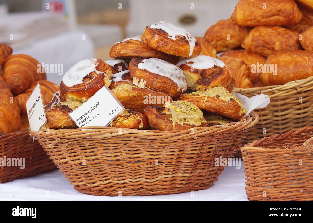 Korb mit süßem Gebäck, Pistazienbrötchen und Walnussbrötchen mit Zuckerglasur und Nüssen auf dem Bauernmarkt. Stockfoto