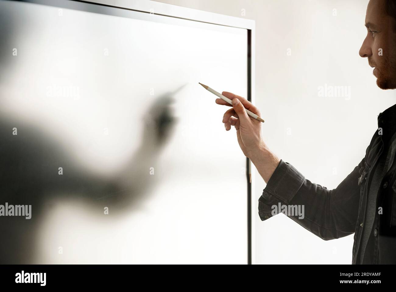 Geschäftsmann mit digitalisiertem Schreibstift auf interaktivem Whiteboard Stockfoto