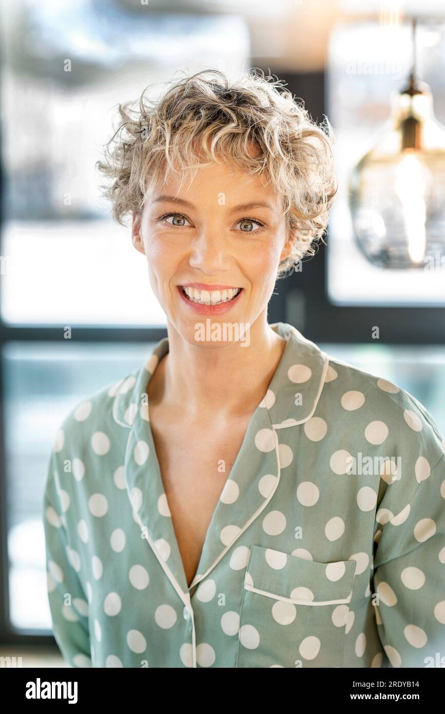 Glückliche blonde Geschäftsfrau mit kurzen Haaren im Büro Stockfoto