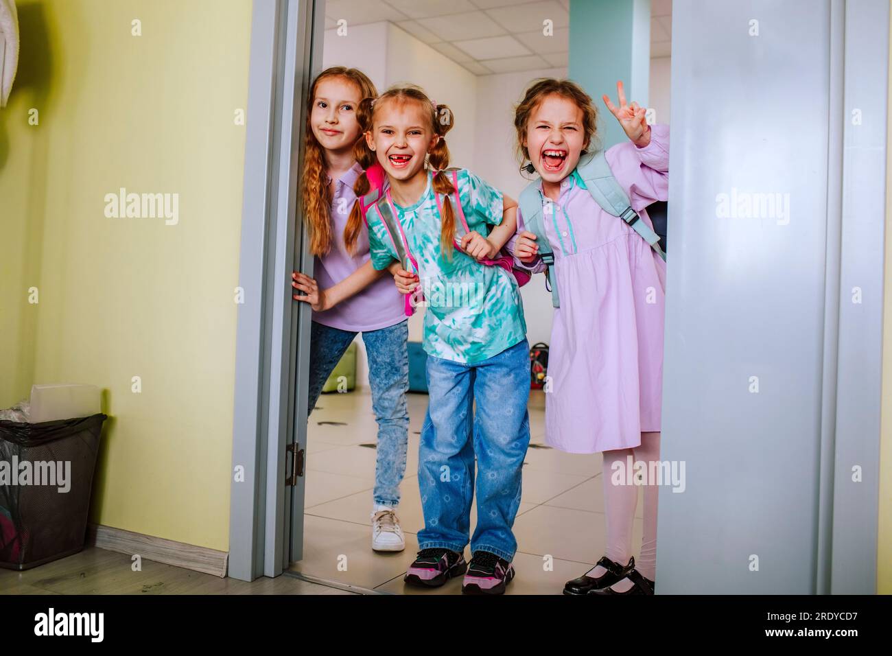 Lächelnde Schulmädchen, die im Klassenzimmer stehen Stockfoto