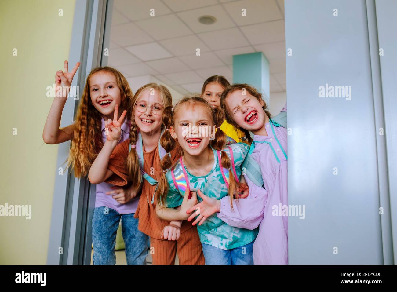 Lächelnde Schulmädchen, die im Klassenraum Gesten machen Stockfoto