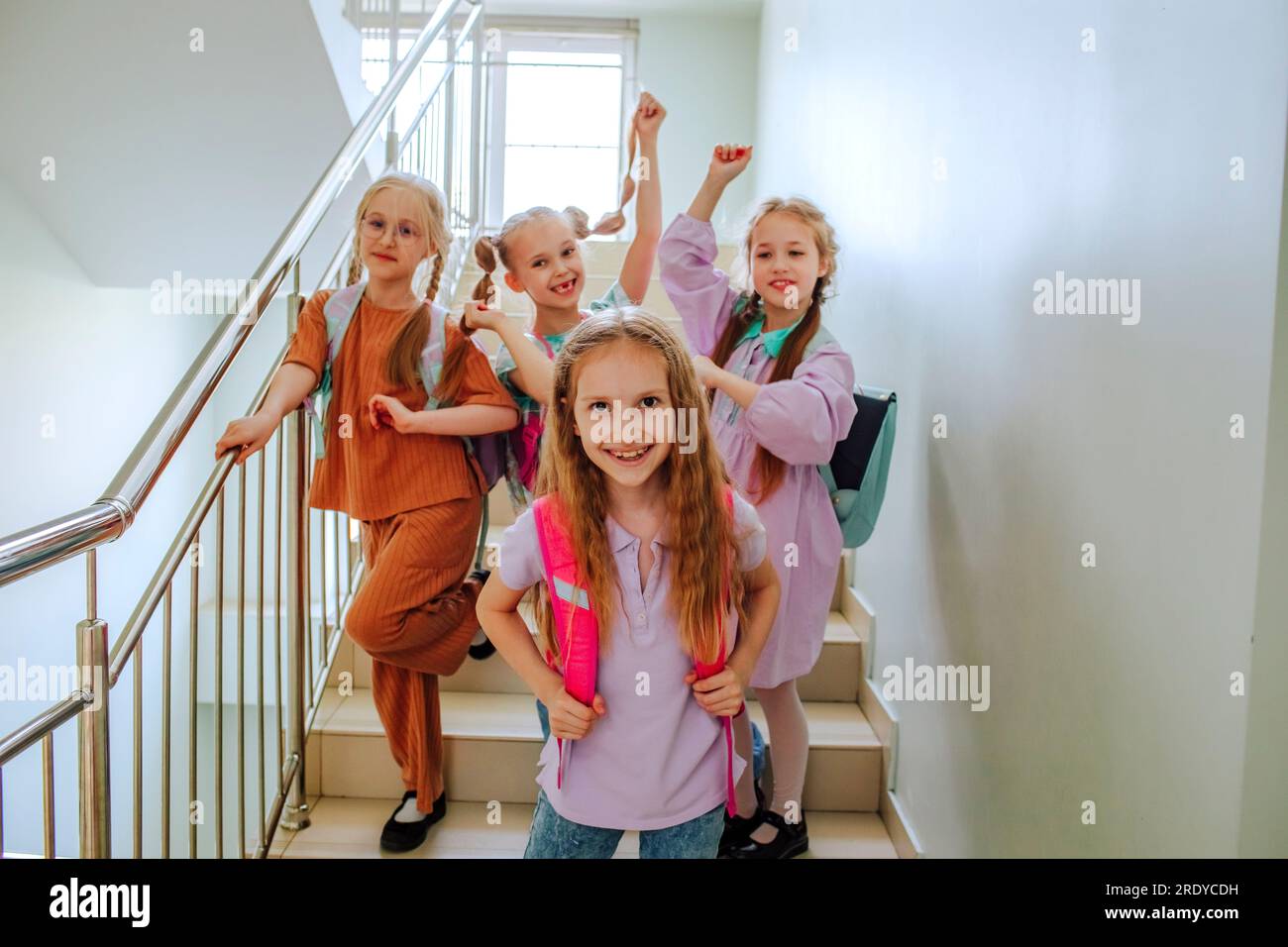 Fröhliche Schulmädchen stehen auf der Schultreppe Stockfoto