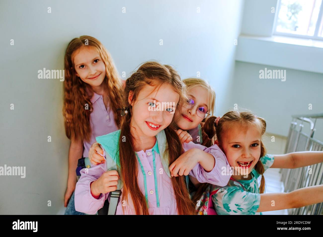 Lächelnde Schulmädchen, die zusammen auf der Treppe standen Stockfoto