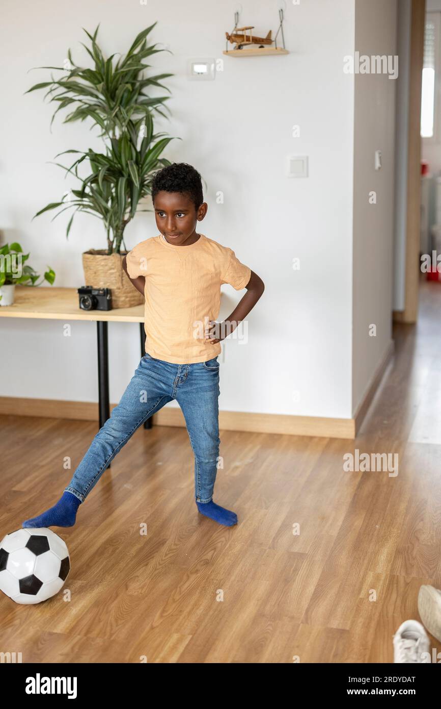 Ein Junge, der zu Hause mit Fußball spielt Stockfoto