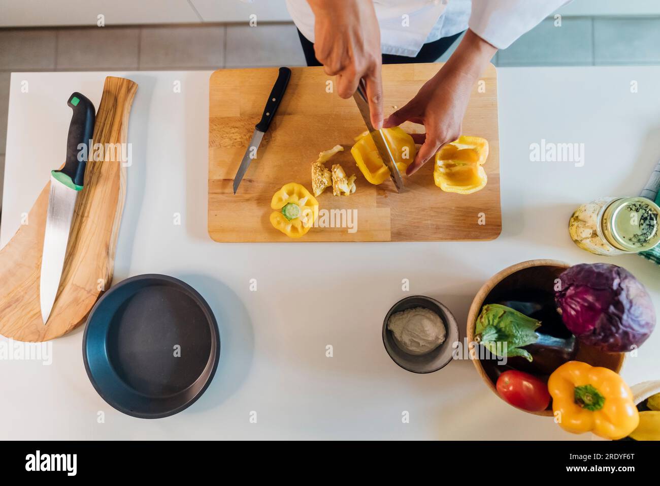 Koch schneidet gelbe Paprika in der Küche zu Hause Stockfoto