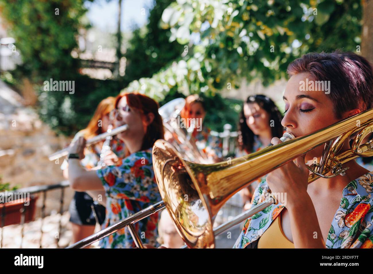 Eine Frau, die Trompete spielt, mit einer Volkskunstgruppe Stockfoto