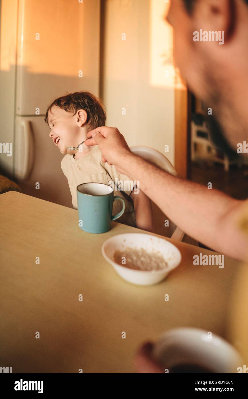 Der Junge weigert sich, Haferbrei am Esstisch zu essen Stockfoto