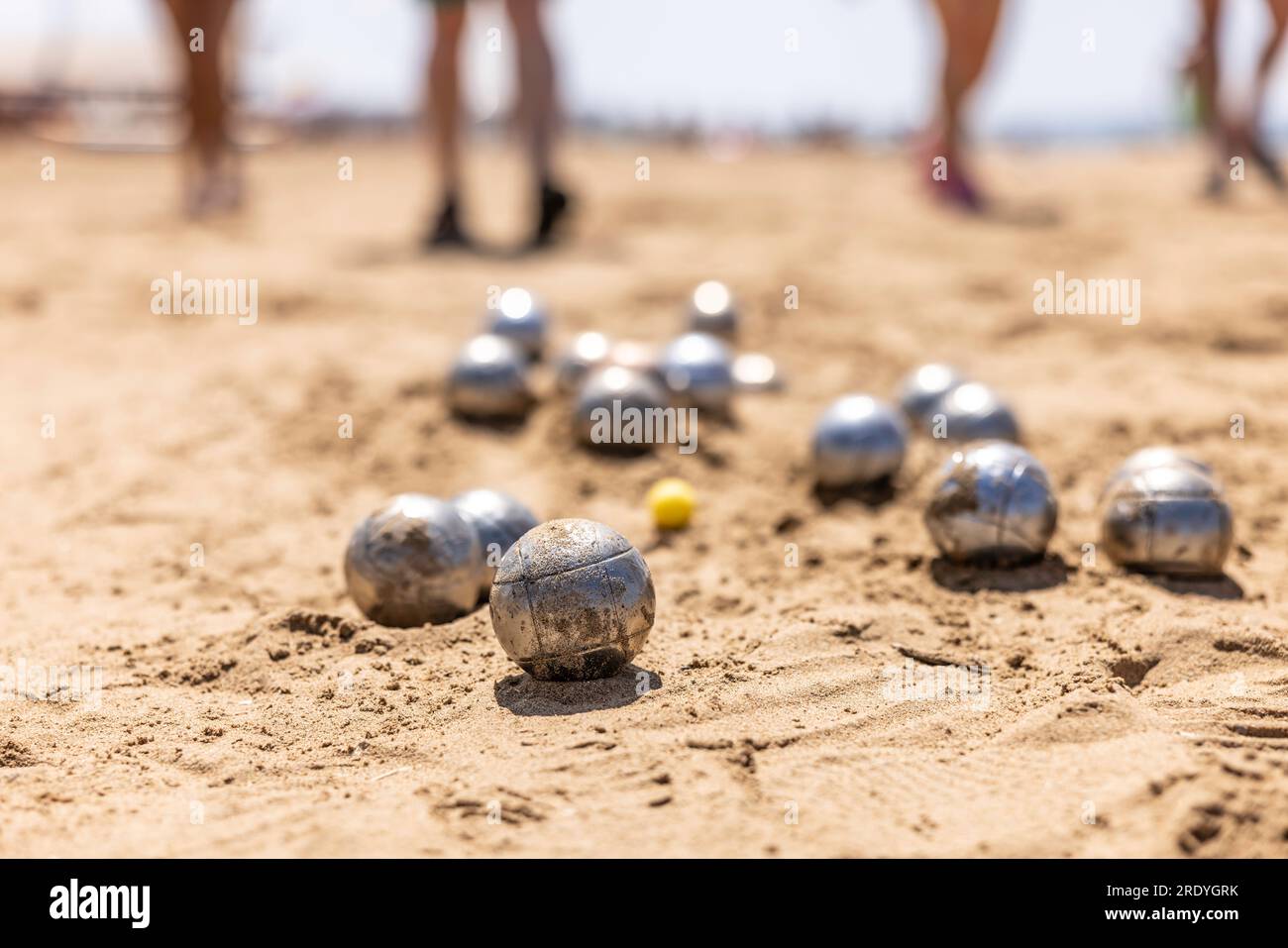 Petanque-Bälle im Sand am Meer während eines Spiels am Strand. Stockfoto