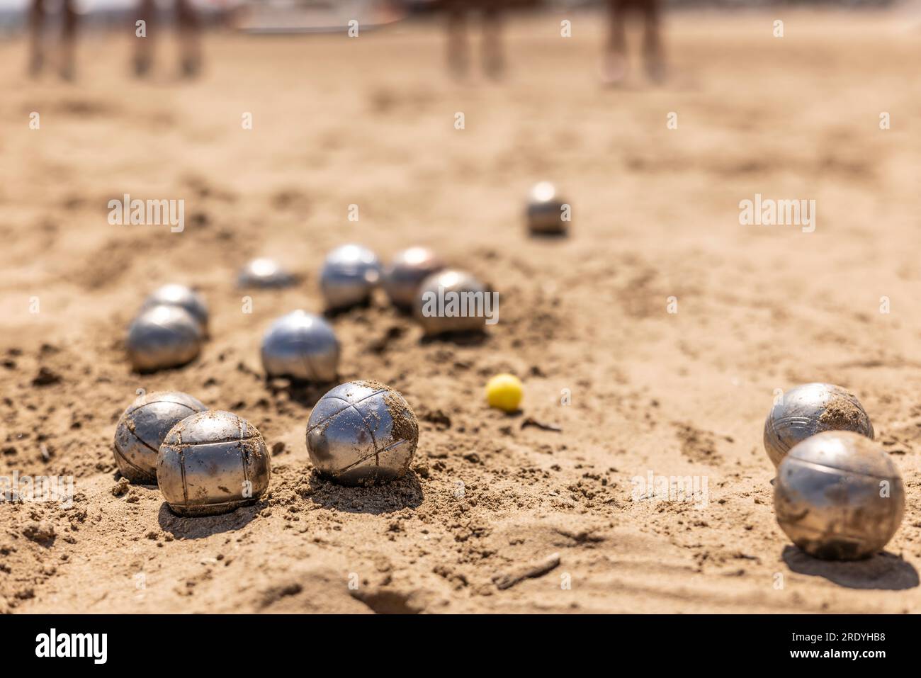 Petanque-Bälle im Sand am Meer während eines Spiels am Strand. Stockfoto