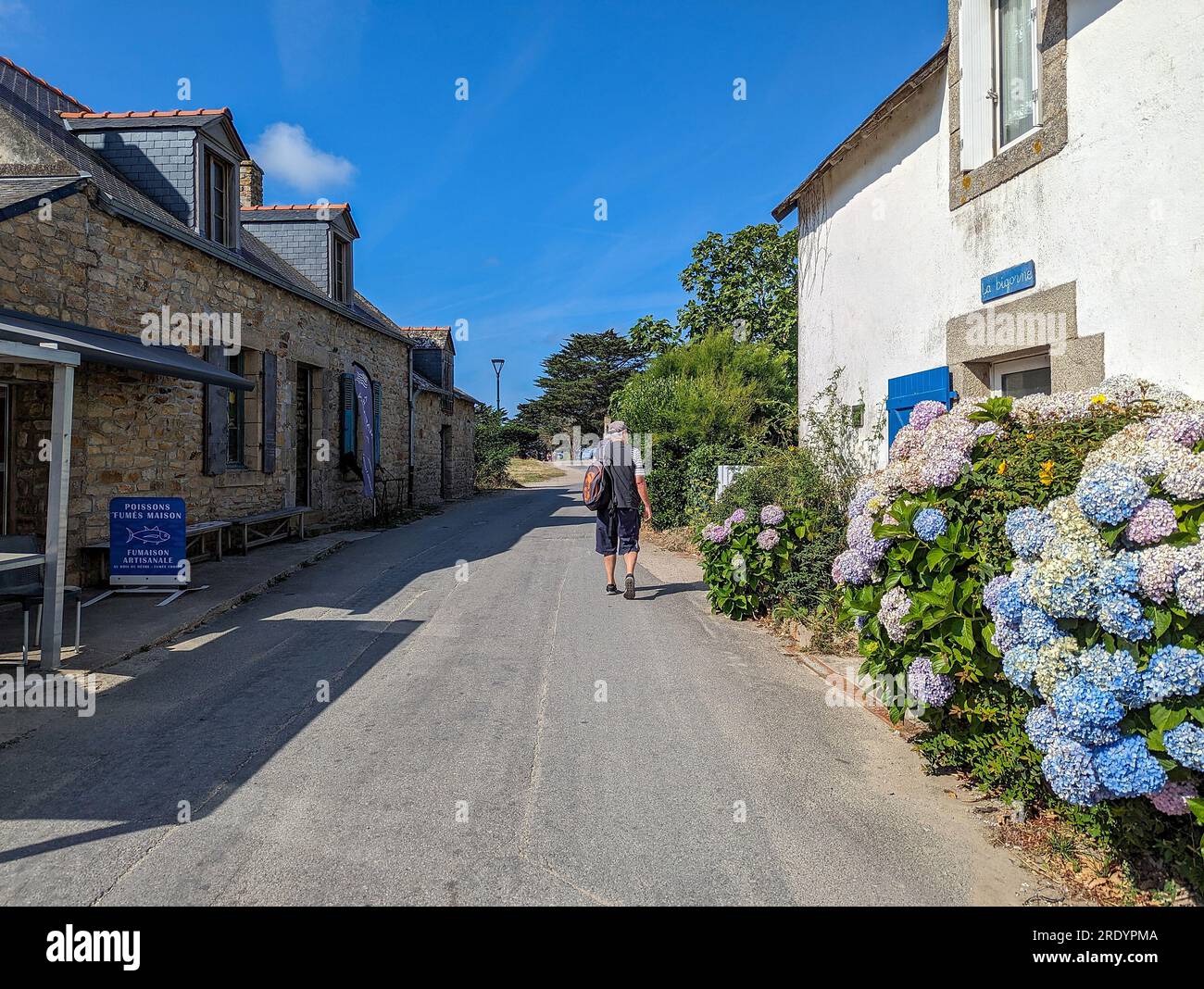 C) Denis TRASFI / MAXPPP - France, Bretagne, Morbihan, île d'Arz (à proximité de l'Île-aux-Moines) le 22 juillet 2023 - Ruelle du bourg avec un rando Stockfoto