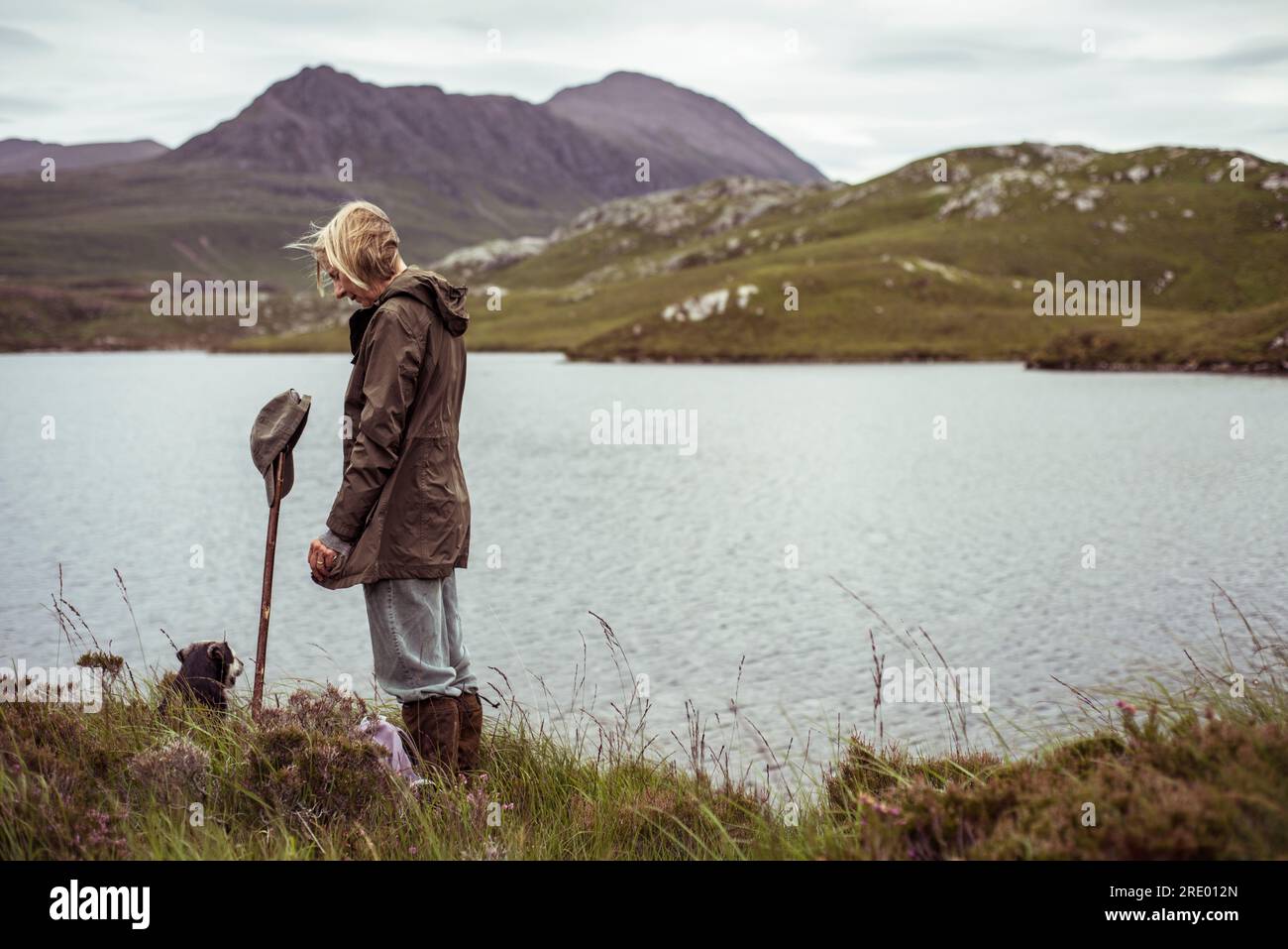 Die Rentnerin steht allein am loch in den schottischen Highlands Stockfoto