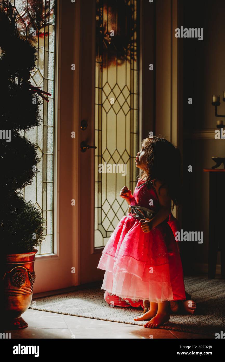 Ein kleines Mädchen, das den Elf im Regal bewundert Stockfoto