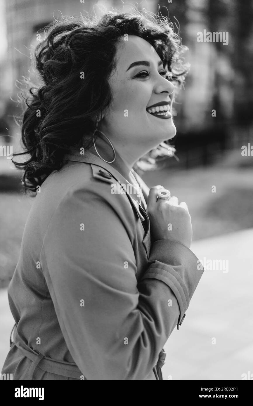 Eine junge Frau, die draußen auf der Straße der Herbststadt lacht Stockfoto