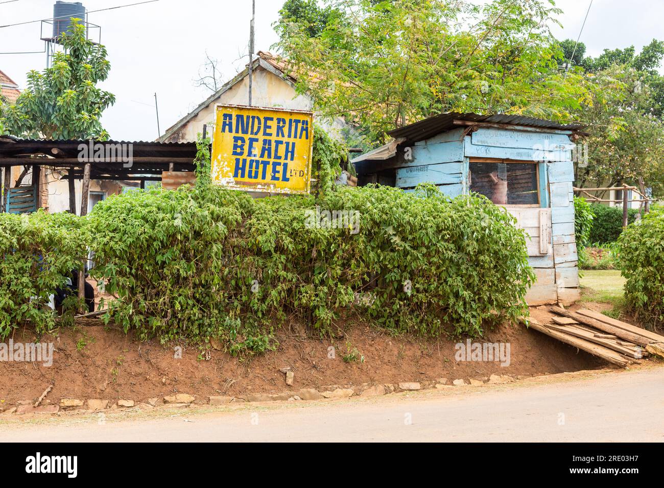 Das Schild „Anderita Beach Hotel“ neben einer Holzhütte dient als Metzgerei. Entebbe, Uganda. Stockfoto