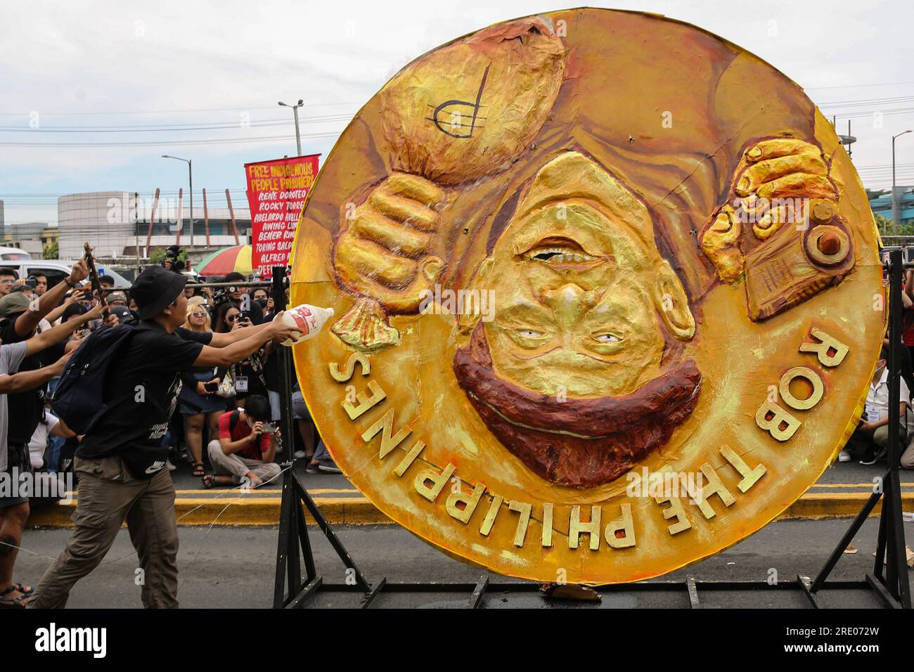 Quezon, Philippinen. 24. Juli 2023. Ein Protestteilnehmer gießt Alkohol ein, um Feuer auszulösen, während er während eines Protests vor der zweiten Rede des philippinischen Präsidenten Ferdinand Marcos Jr. einen Abdruck verbrennt Ein Protest für das erste Jahr der Marcos-Regierung und für die zweite Rede des Präsidenten zur Lage der Nation. Multisektorale Gruppen, die ihre Anliegen zu verschiedenen sozialen Fragen zum Ausdruck bringen. (Foto: Earvin Perias/SOPA Images/Sipa USA) Guthaben: SIPA USA/Alamy Live News Stockfoto