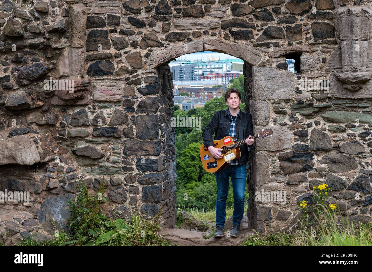 St Anthony's Chapel Holyrood Park, Edinburgh, Schottland, Großbritannien, 24. Juli 2023. Mike Baillie Musikvideo für Fringe Show: Frontman von Band The Lonely Together filmt ein neues Musikvideo für seine Debüt-Fringe-Show Endless Sunset Oblivion, die die Geschichte eines jungen Songwriters Reuben erzählt, der versucht, die beschleunigten Probleme der Welt zu bekämpfen. Der Song im Video wurde an diesem Ort geschrieben. Kredit: Sally Anderson/Alamy Live News Stockfoto