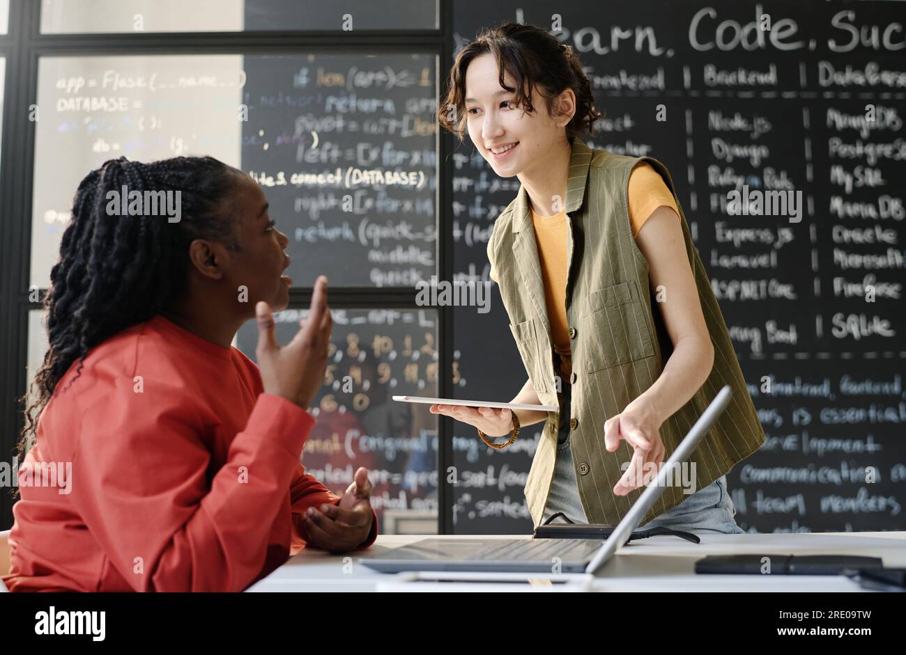 Schüler mit Tablet-pc, der während DES IT-Unterrichts mit einem Lehrer im Klassenzimmer spricht Stockfoto
