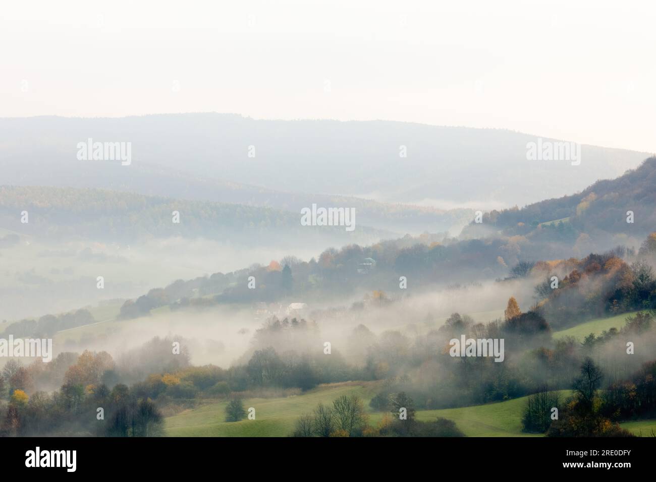 Ländliche Herbstlandschaft mit Wald. Nebiger Morgen. Ein Tal mit kleinen Häusern. Wolkiger Himmel. Draufsicht, Horna Suca, Slowakei Stockfoto