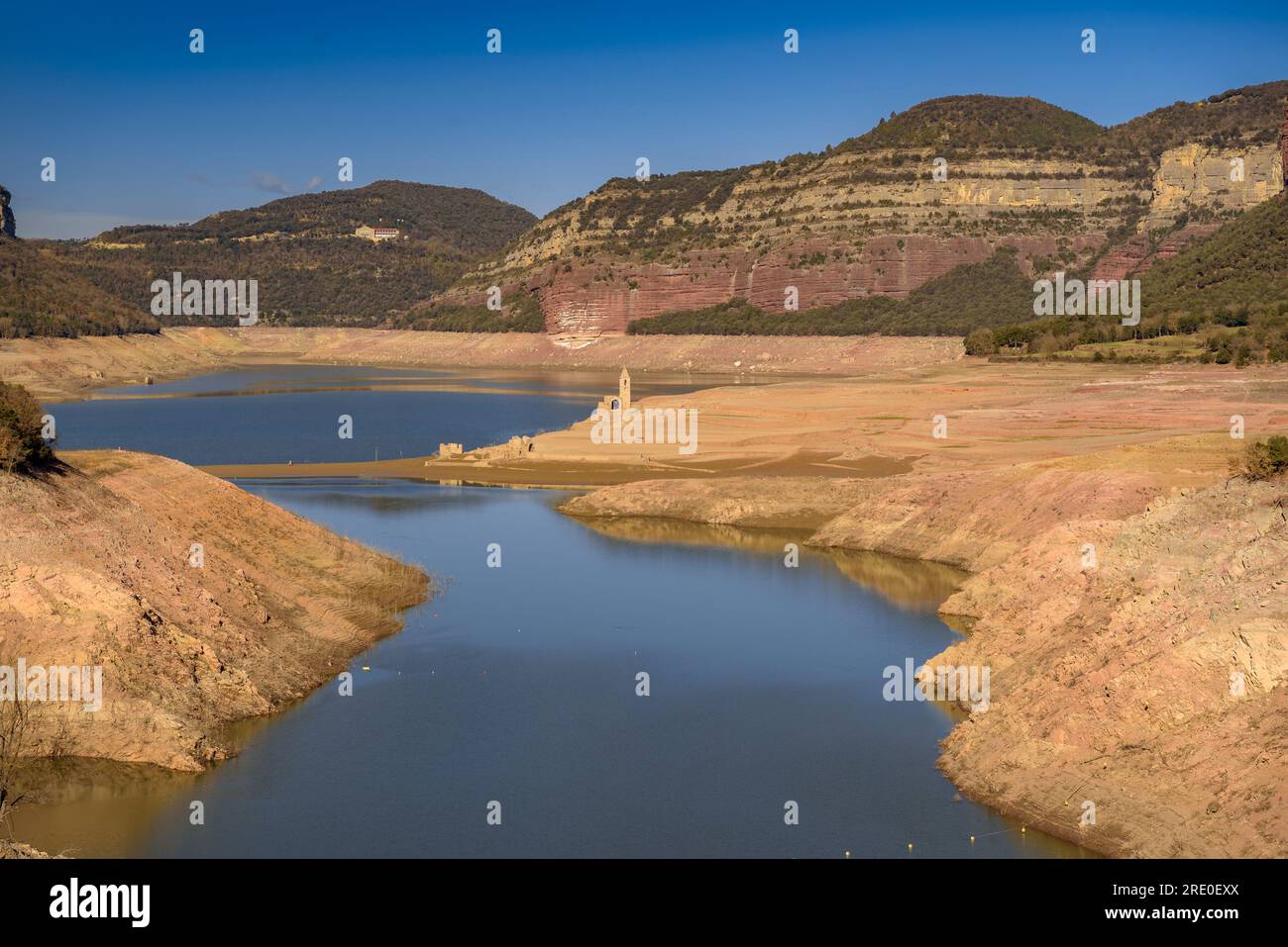 Das Sau-Reservoir ist während der Entleerung des Reservoirs im März 2023 mit dem Glockenturm von Sant Romà de Sau in der Mitte des Tals fast leer Stockfoto