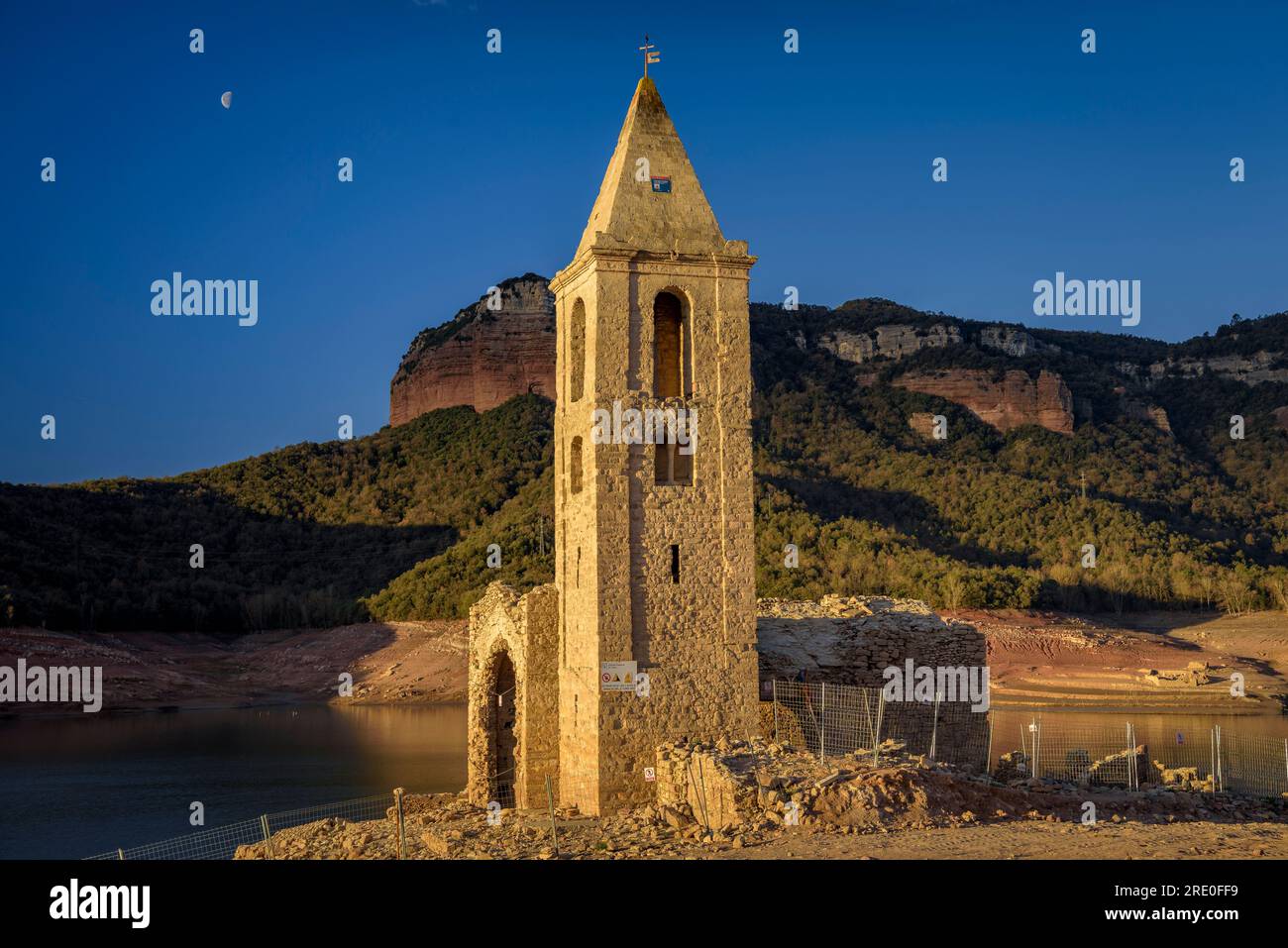 Glockenturm von Sant Romà de Sau bei Sonnenaufgang mit fast leerem Sau-Reservoir während der Dürre 2022-23 (Osona, Barcelona, Katalonien, Spanien) Stockfoto