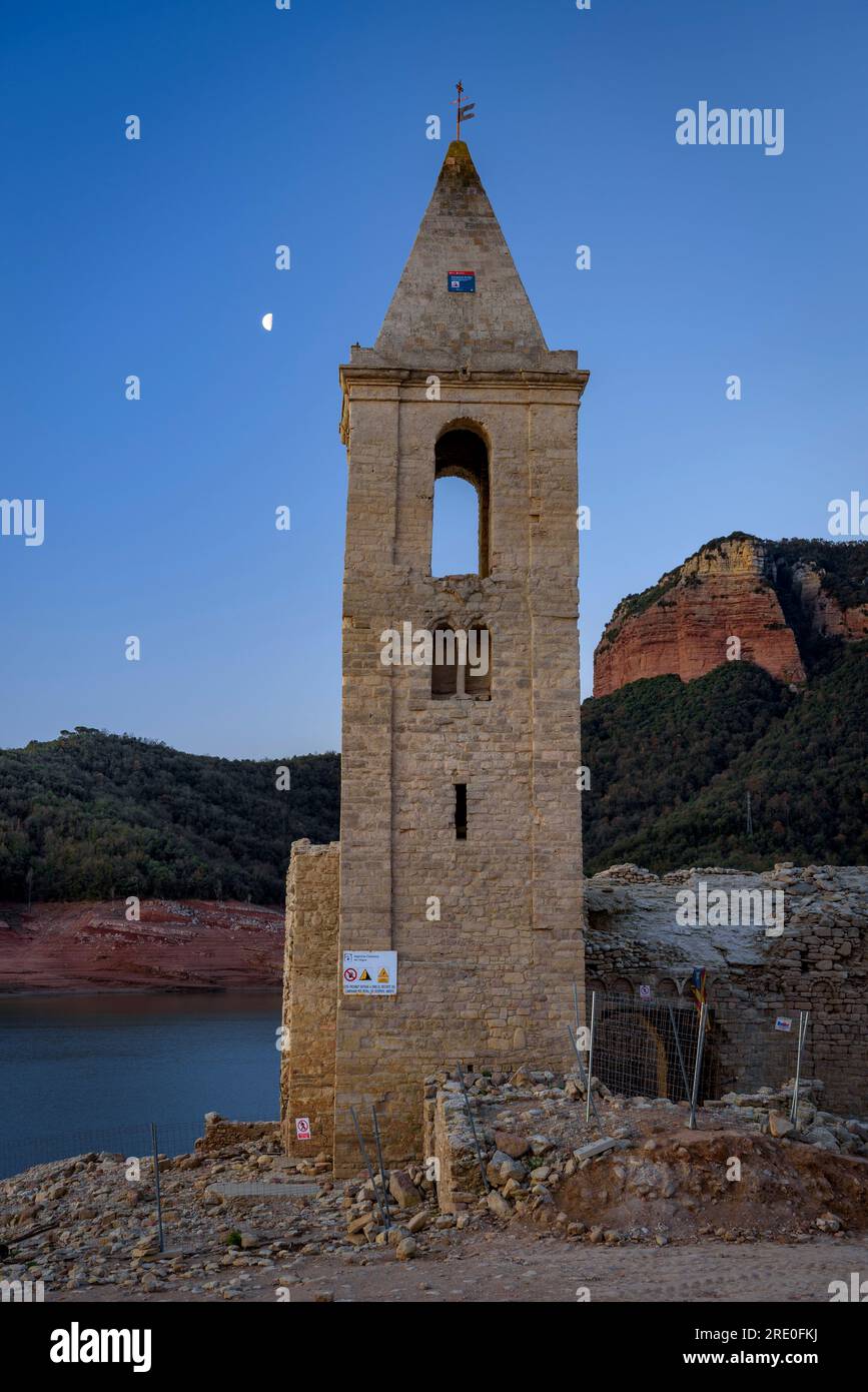 Glockenturm von Sant Romà de Sau bei Sonnenaufgang mit dem sinkenden Mond während der Dürre 2022-23 (Osona, Barcelona, Katalonien, Spanien) Stockfoto