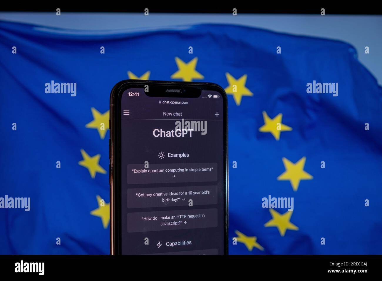 Azoren, Portugal - 21.01.2023: Smartphone mit ChatGPT-Webseite und einer verschwommenen Flagge der Europäischen Union auf dem Laptop-Bildschirm als Hintergrund. KI-Compliance mit Stockfoto