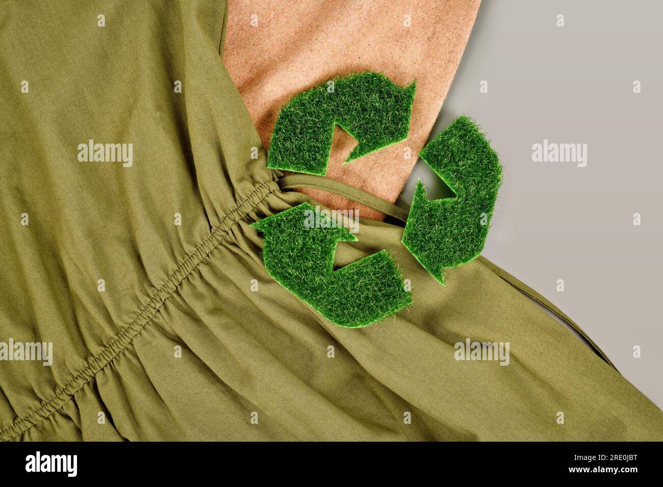 Umweltfreundliche hergestellte Kleidung mit Recycling-Pfeil-Symbol aus Gras Stockfoto