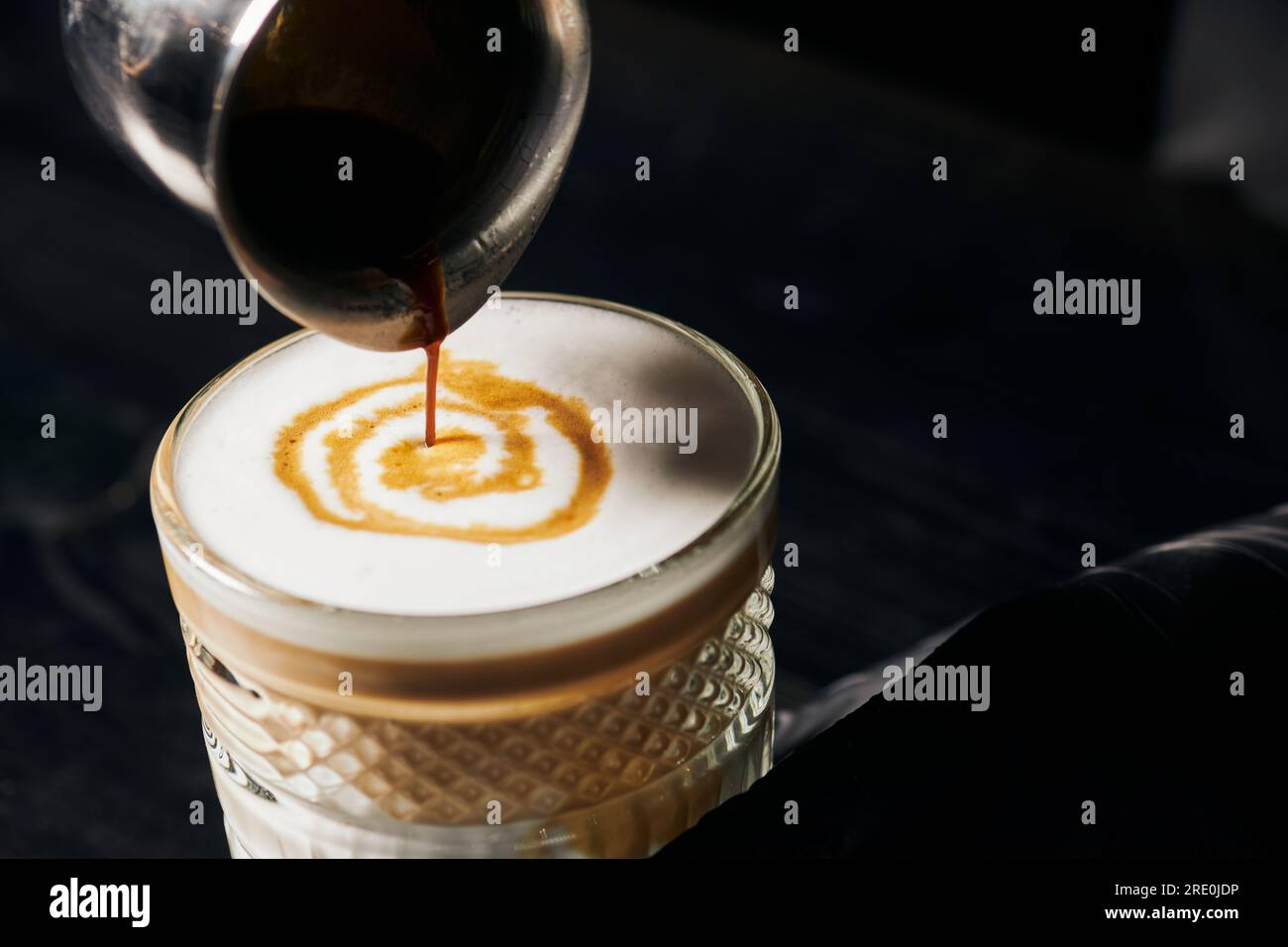 Latte Macchiato, Espresso in Glas, Krug mit Kaffee, Milchschaum, Energie und Koffein Stockfoto