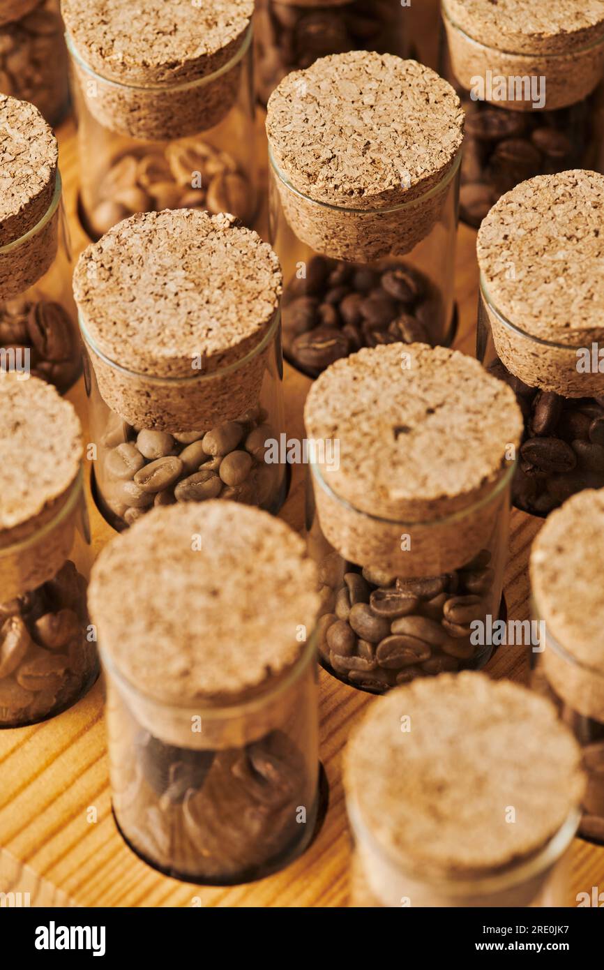 Kaffeebohnen in Glasgefäßen mit Kork, unterschiedlicher Röstung, Koffein und Energie, Kaffeehintergrund Stockfoto