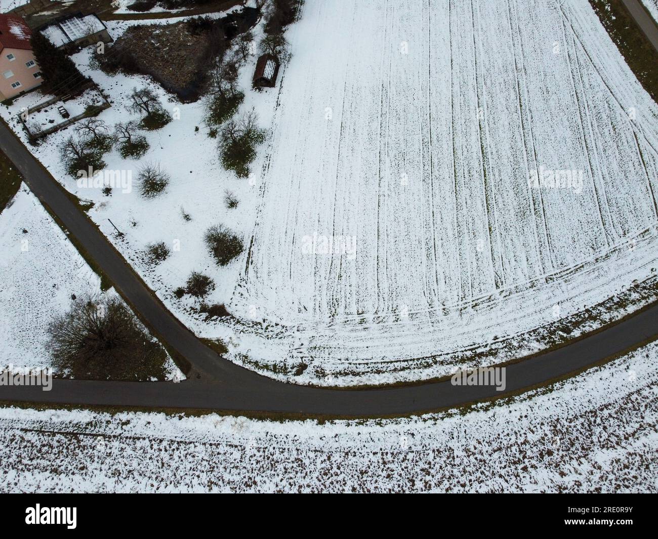 Schneebedeckte landwirtschaftliche schneebedeckte Felder in bayern an einem bewölkten Tag Stockfoto