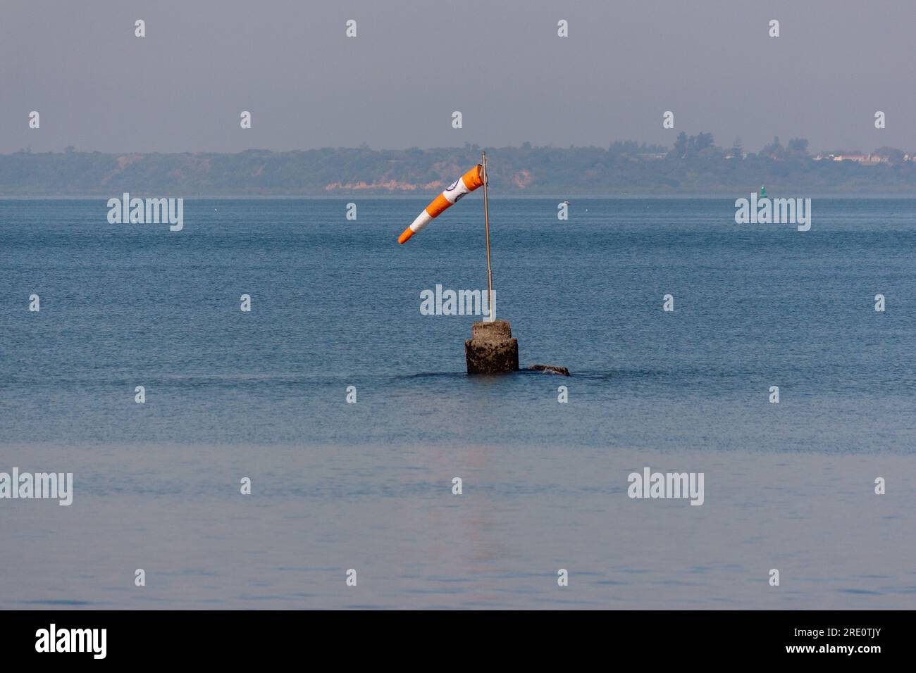 Eine Windsocke oder ein Windkegel, der in Windrichtung in der Mitte des Meeres zeigt Stockfoto