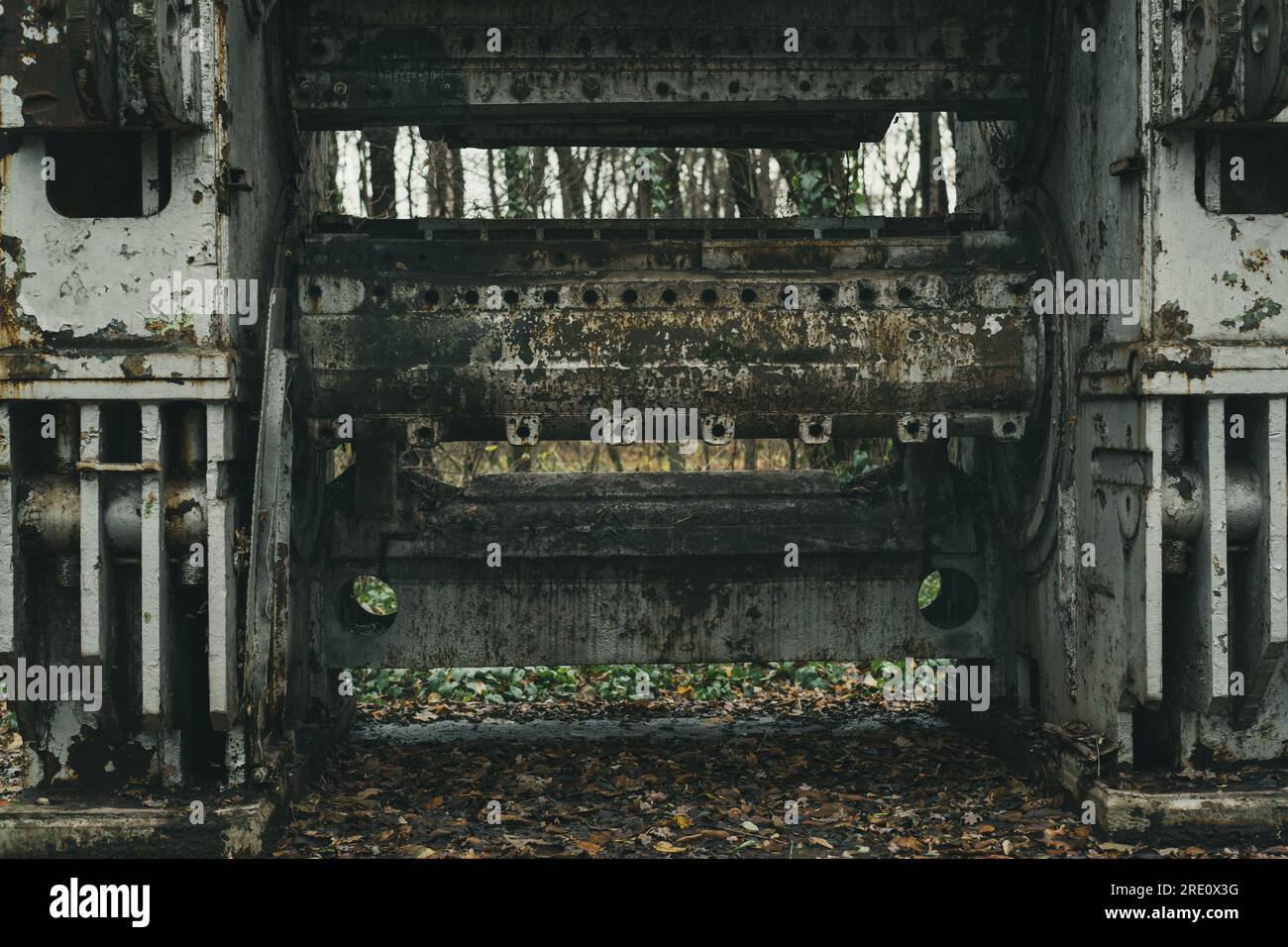 Detail einer alten verlassenen und verrosteten Blechbearbeitungsmaschine im Wald. Eisen- und Stahlproduktion. Industrielle Geschichtsmaschine. Stockfoto