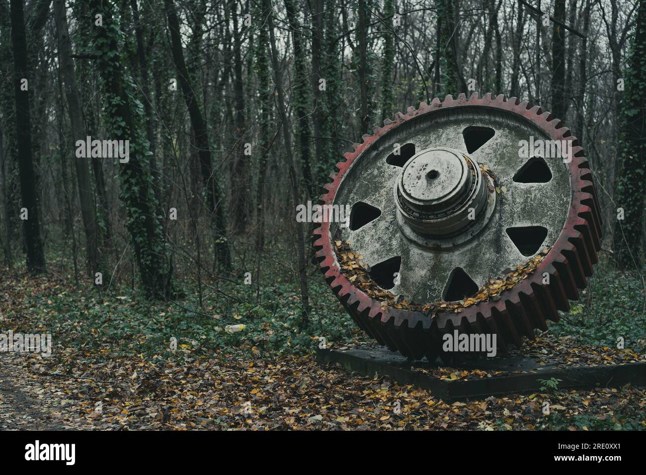 Eine alte, unbenutzte riesige Ausrüstung im Herbst im Wald. Industrielle Geschichtsmaschine. Verlassene Maschinen. Eisen- und Stahlproduktion. Stockfoto