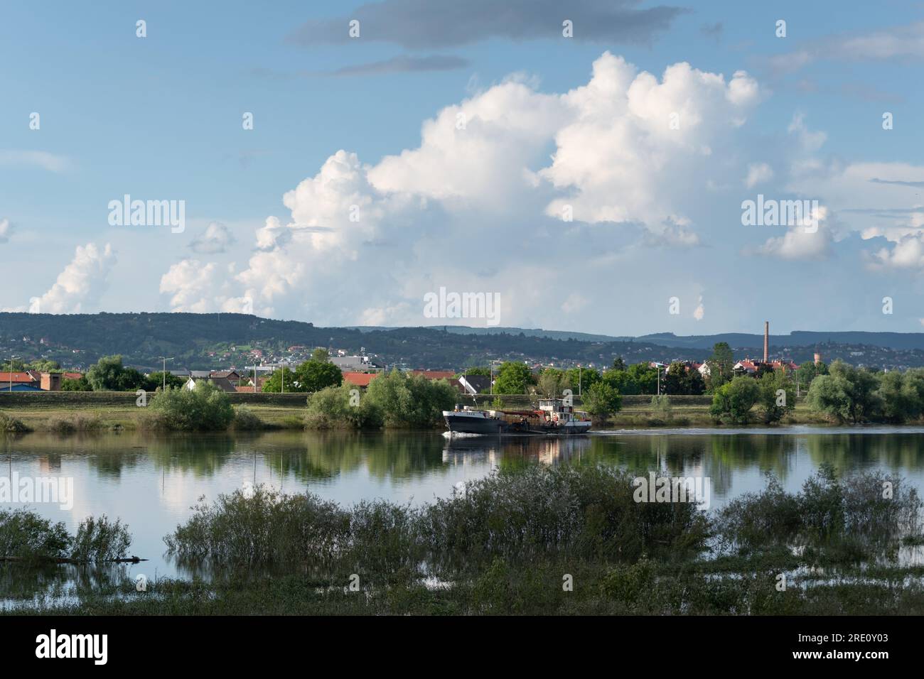 Das Schiff segelt auf dem Fluss Sava und einer großen Wolke am Himmel, Landschaft mit Fluss und Cumulus Wolke Stockfoto