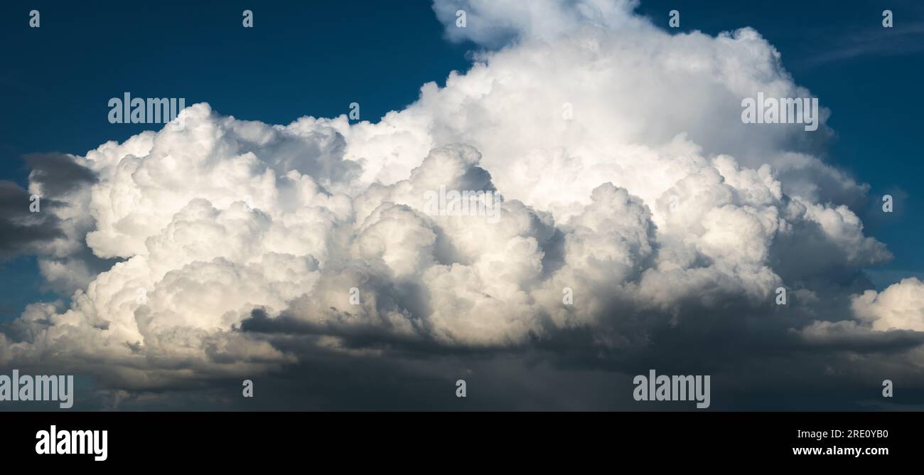 Kontrastreiche Szene einer riesigen hellen Wolke vor blauem Himmel, abstrakte Landschaft Stockfoto