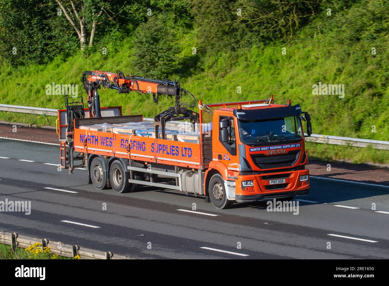 North-West Roofing Supplies Lastwagen für Baumaterialien; 2017 Iveco Stralis Ad260s33y/PS S-A Orange, der auf der Autobahn M6 in Greater Manchester, Großbritannien, fährt Stockfoto