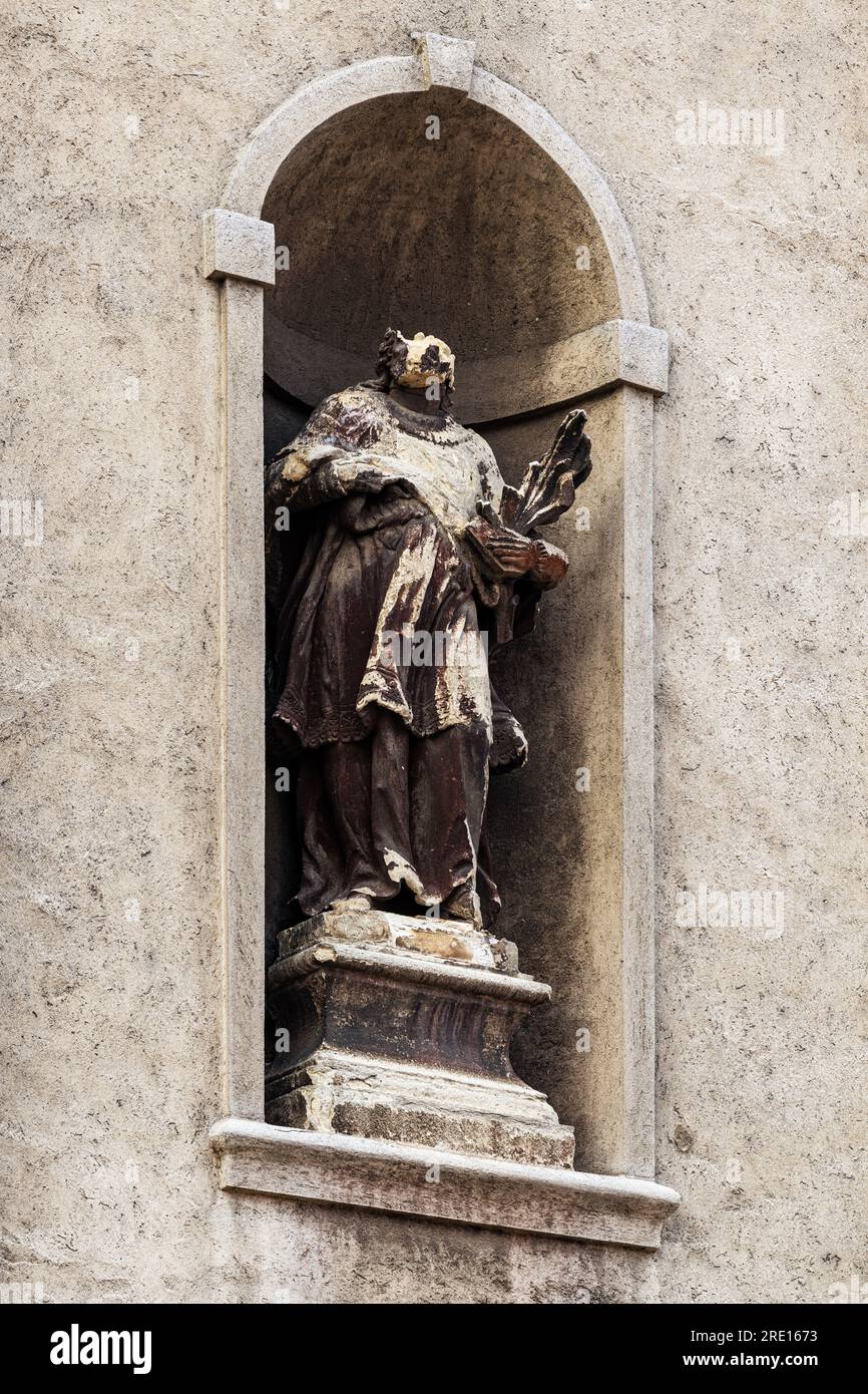 Abgenutzte und beschädigte Statue an der katholischen Kirchenfassade, Details der christlichen Architektur Stockfoto