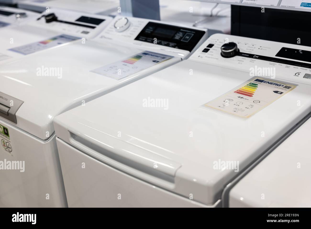 Energieeffizienzkennzeichnung an einer Waschmaschine in einem Haushaltsgerätehaus. Energieetiketten auf einer Skala von A bis G, je nachdem wie viel e Stockfoto