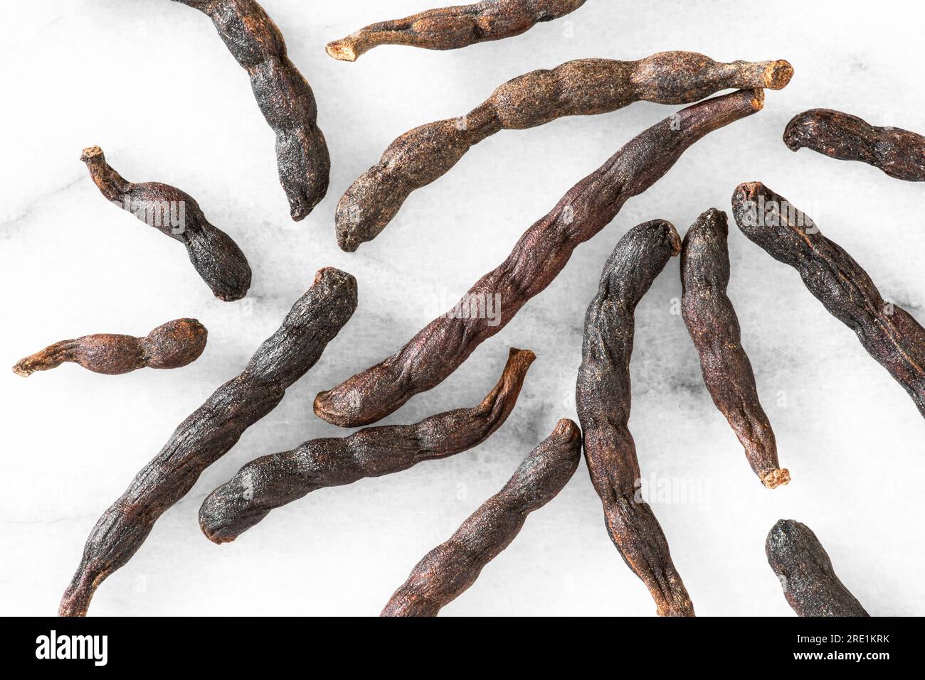 Nahaufnahme von verlängerten afrikanischen schwarzen Paprika-Schoten auf weißem Marmorhintergrund Stockfoto