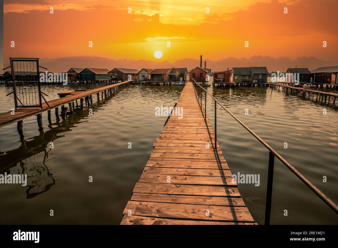 Angelhäuser, Ferienhaus, Holzhaus im See mit Steg. Bokod Ungarn Bora Bora Landschaft mit Sonnenuntergang Stockfoto