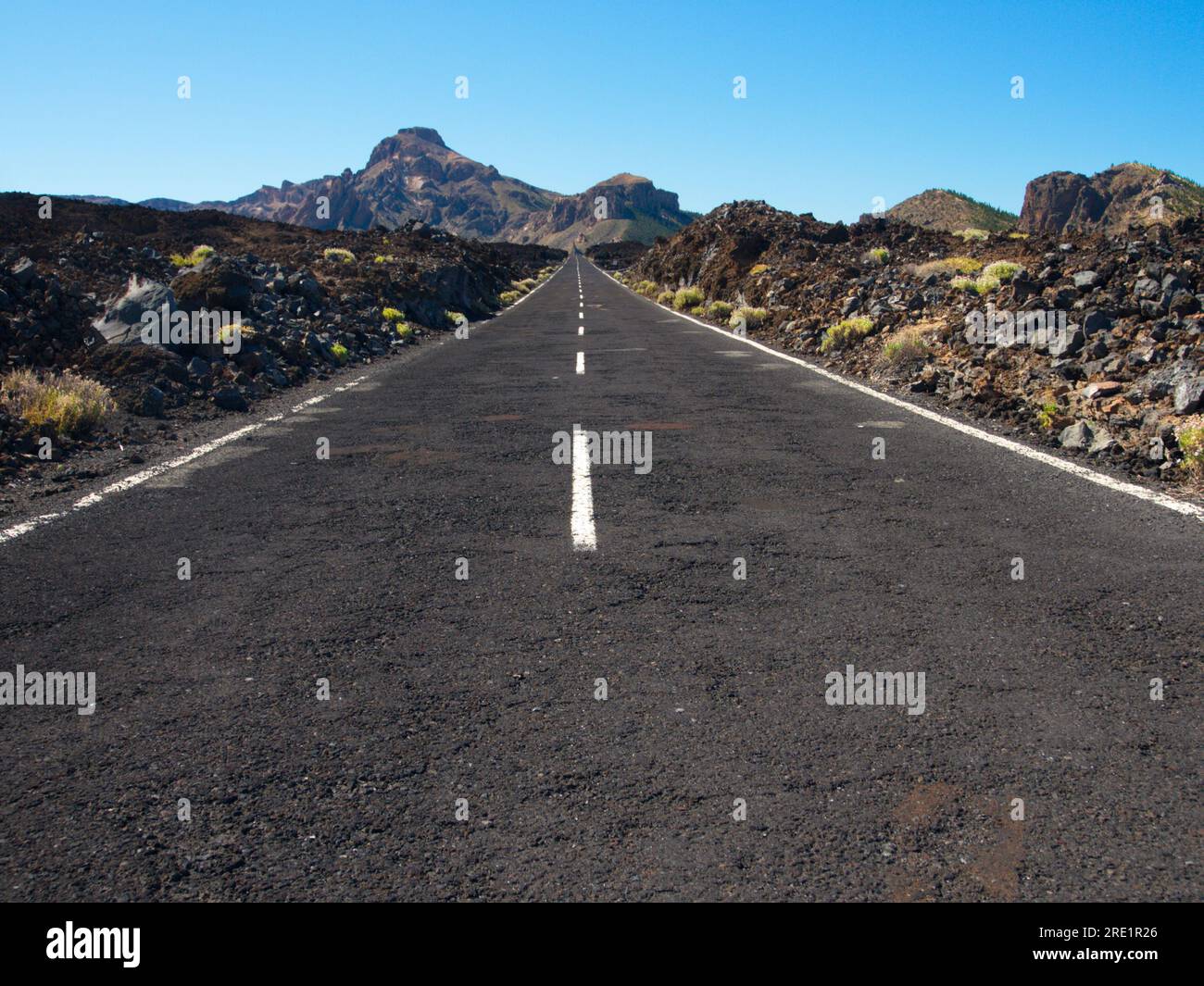Eine gerade Straße mit Markierungen am Horizont in Las Cañadas del Teide, una carretera recta con las marcas convergiendo en el horizonte. Stockfoto