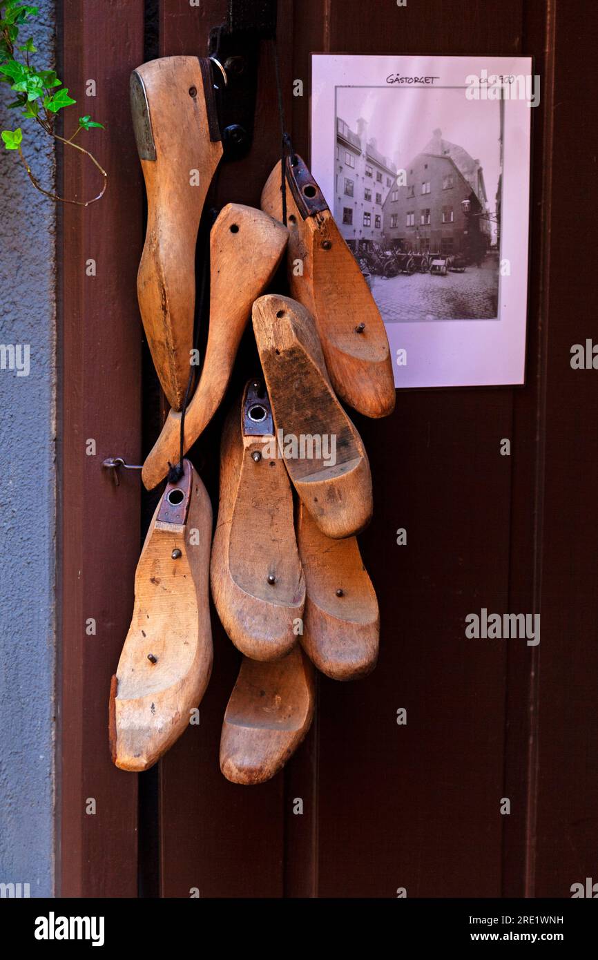 Viele Vorlagen für Schuhe aus Holz hängen außerhalb der Schuhmacherwerkstatt Stockfoto