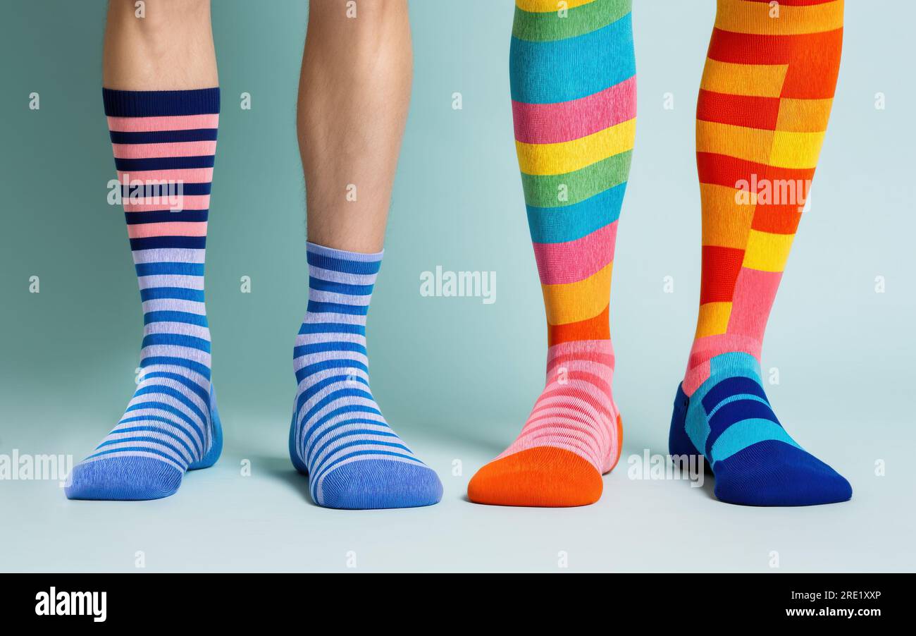 Die Socken sind in verschiedenen Farben auf den Füßen Stockfoto